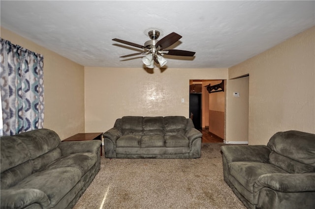 living room featuring carpet flooring, ceiling fan, and a textured ceiling