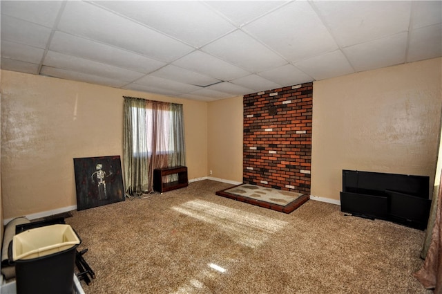 unfurnished living room featuring carpet flooring and a drop ceiling