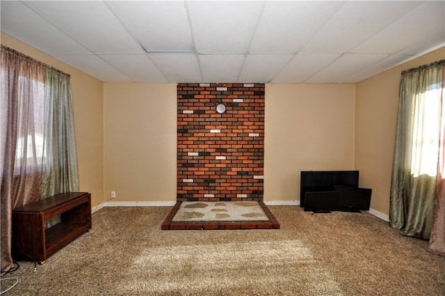 living area featuring carpet flooring and a paneled ceiling