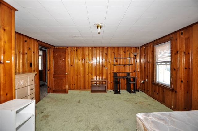 carpeted bedroom with wood walls