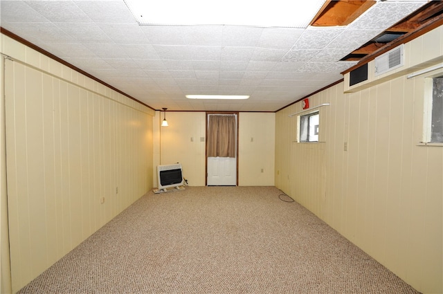 basement with carpet floors, crown molding, and heating unit