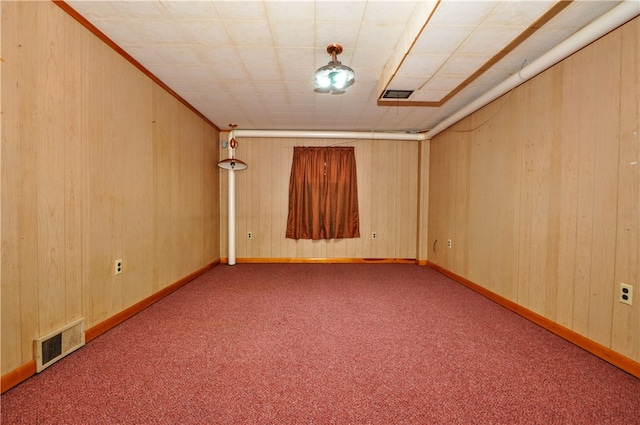 unfurnished room with wooden walls and light colored carpet