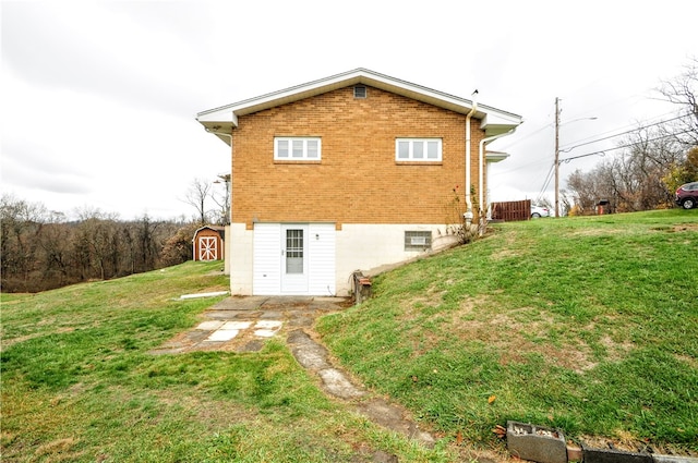 view of side of property with a storage unit and a lawn