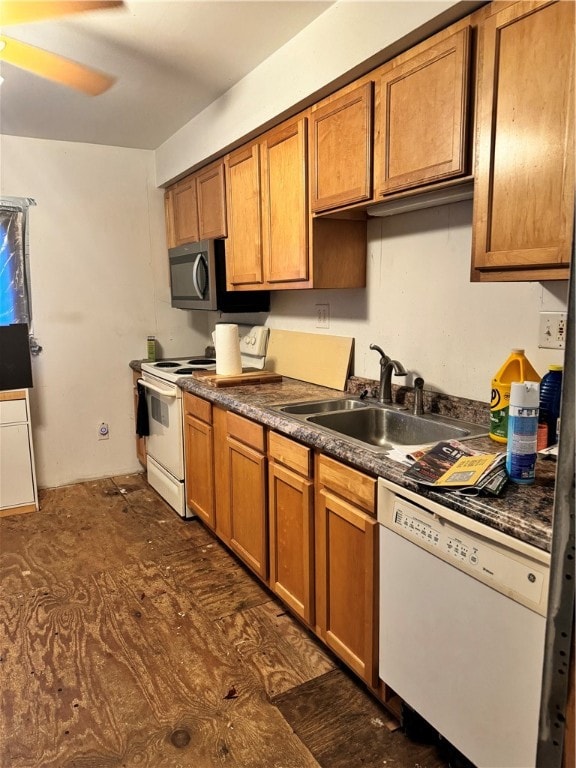 kitchen featuring ceiling fan, white appliances, sink, and dark wood-type flooring