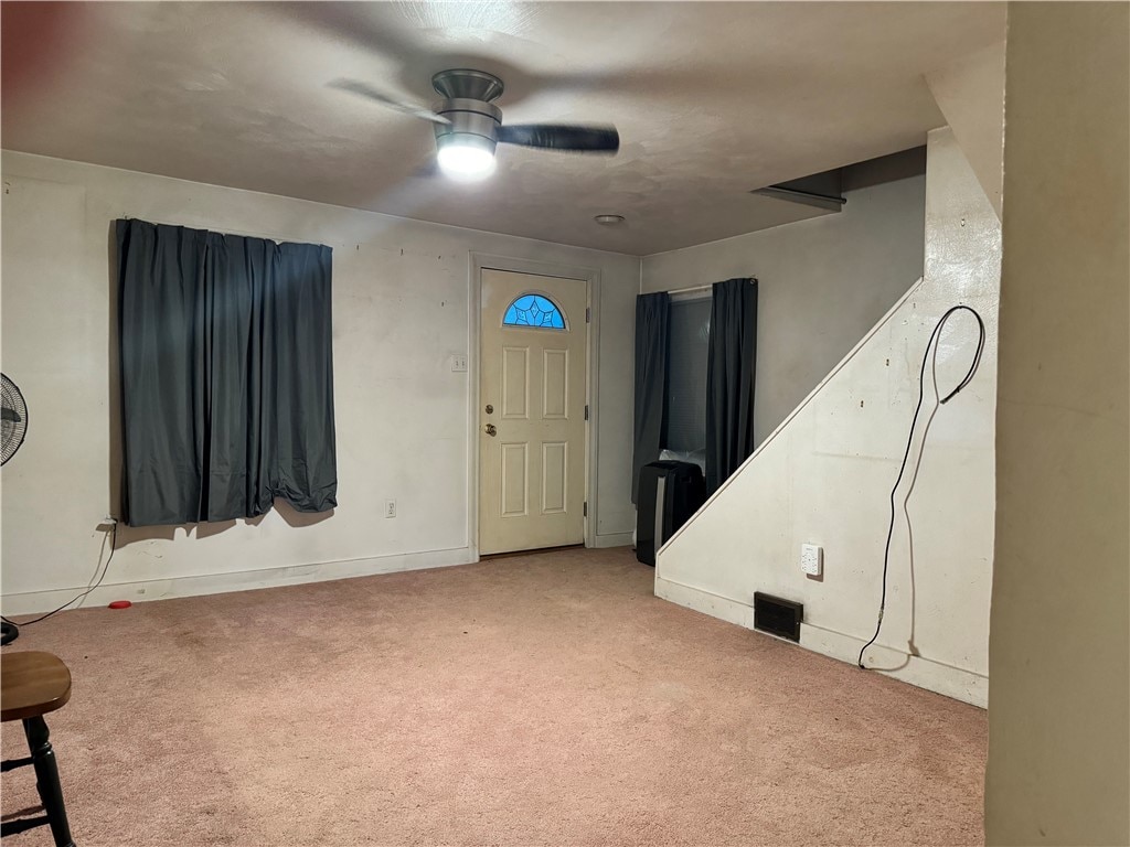 carpeted entrance foyer featuring ceiling fan