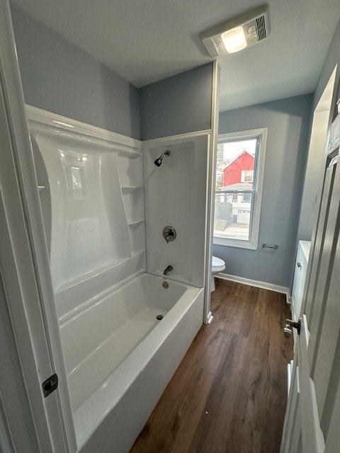 bathroom featuring hardwood / wood-style floors, toilet, and shower / tub combination