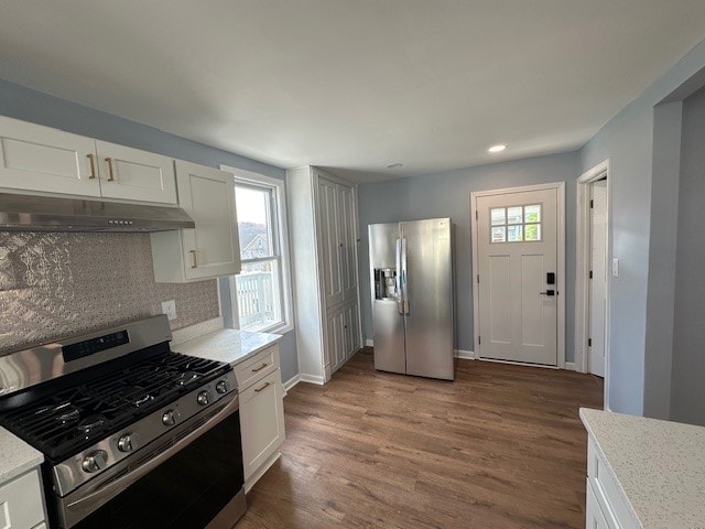 kitchen featuring stainless steel appliances, white cabinetry, and plenty of natural light