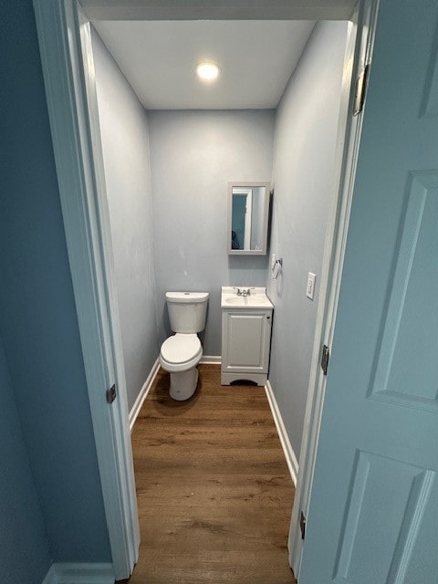 bathroom with hardwood / wood-style floors, vanity, and toilet