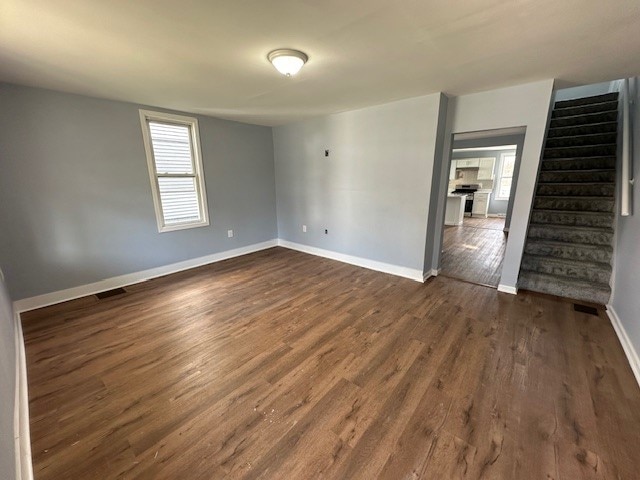 spare room with dark hardwood / wood-style floors and a healthy amount of sunlight