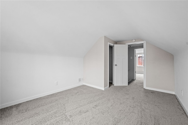 additional living space with carpet and vaulted ceiling