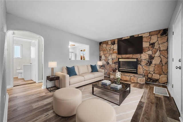 living room with wood-type flooring and a fireplace