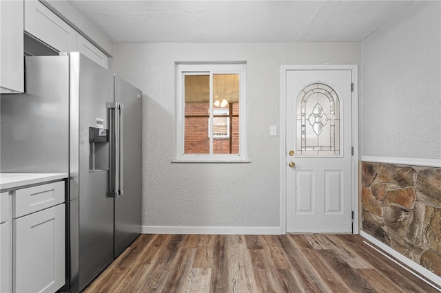 foyer entrance with a textured ceiling and dark hardwood / wood-style floors