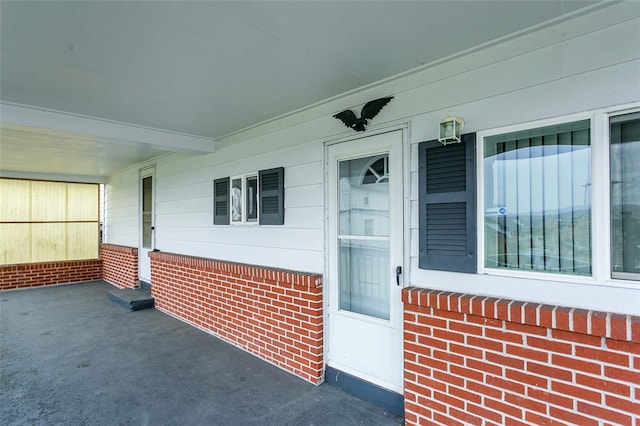 view of exterior entry featuring covered porch