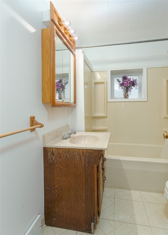 full bathroom with vanity, a baseboard heating unit, toilet, and bathing tub / shower combination