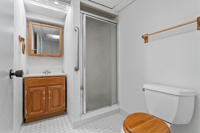 bathroom with toilet, an enclosed shower, and vanity