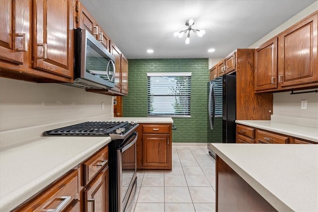 kitchen featuring light tile patterned floors, stainless steel appliances, and a notable chandelier