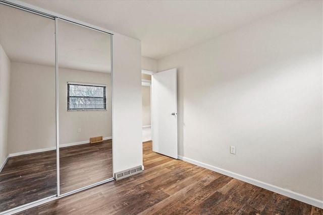 unfurnished bedroom with hardwood / wood-style flooring and a closet