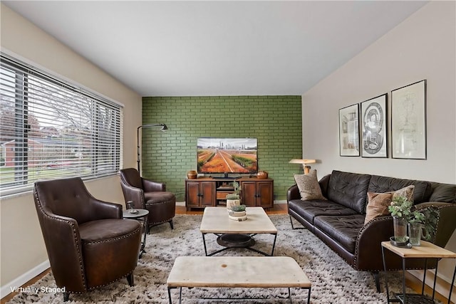 living room featuring light hardwood / wood-style floors and brick wall