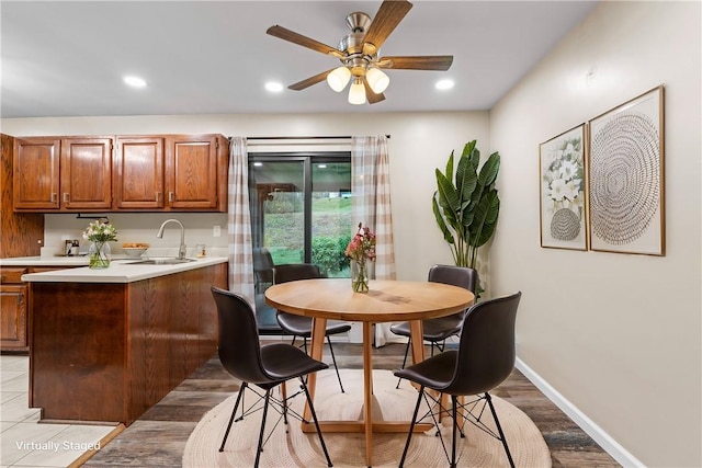 dining area featuring light hardwood / wood-style flooring, ceiling fan, and sink