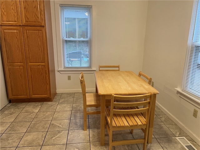 tiled dining space featuring a healthy amount of sunlight