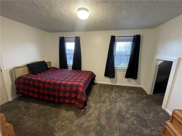 carpeted bedroom featuring a textured ceiling and multiple windows