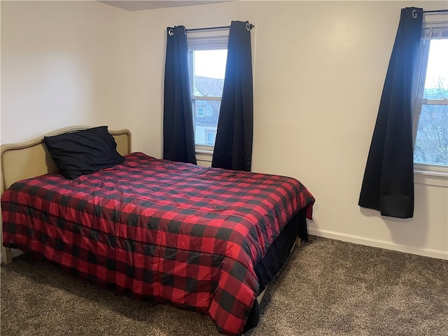 bedroom with multiple windows and dark colored carpet