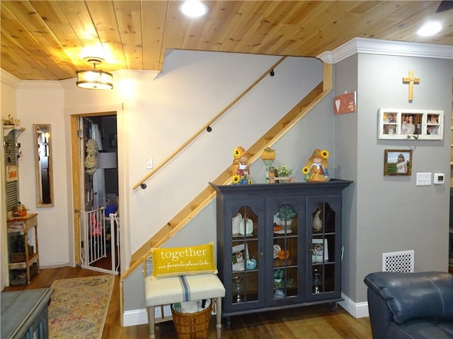 sitting room featuring dark wood-type flooring, crown molding, and wooden ceiling