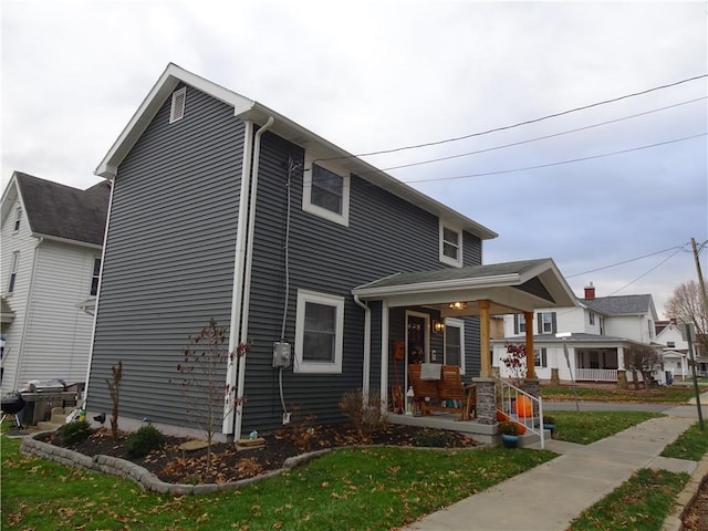 view of front of property featuring covered porch and a front lawn