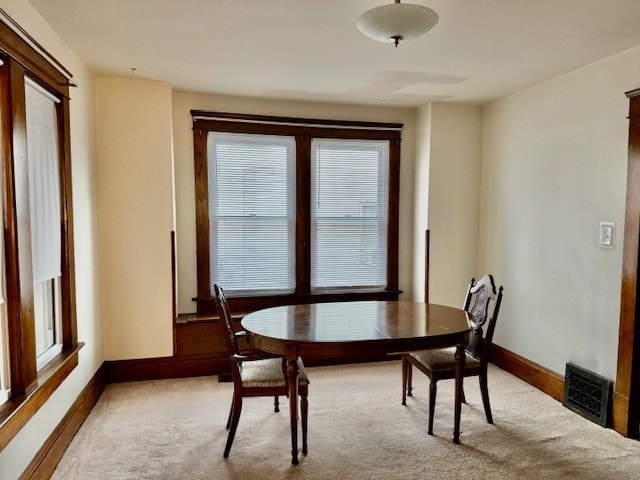 dining space featuring light carpet