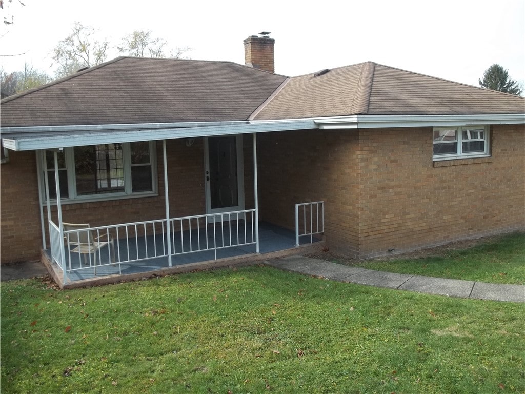 exterior space featuring a lawn and a porch