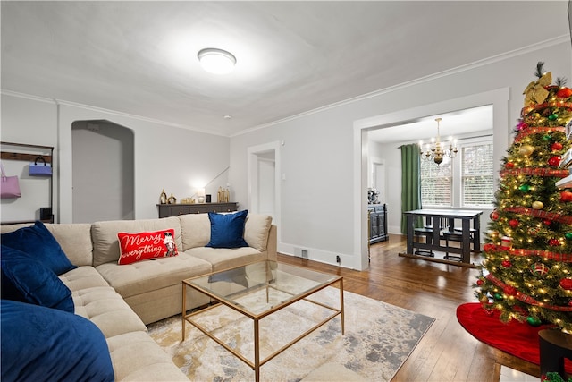 living room with crown molding, a chandelier, and hardwood / wood-style flooring