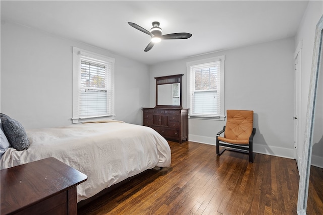 bedroom with ceiling fan, dark wood-type flooring, and multiple windows