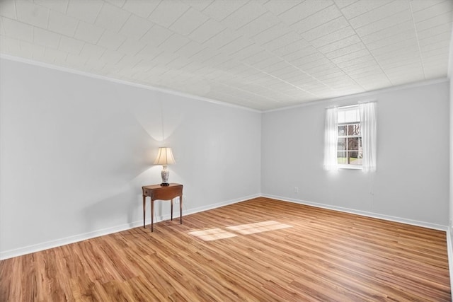 empty room featuring hardwood / wood-style floors and ornamental molding