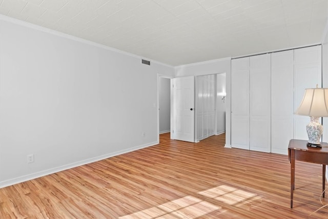 unfurnished bedroom with light hardwood / wood-style floors, a closet, and ornamental molding