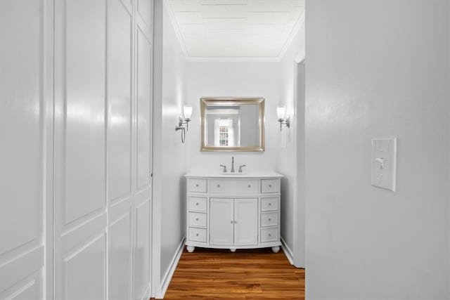 bathroom with vanity, ornamental molding, and hardwood / wood-style flooring