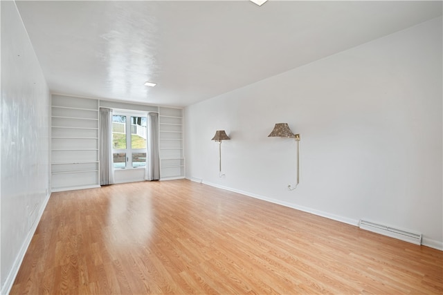 spare room with a baseboard radiator and light wood-type flooring