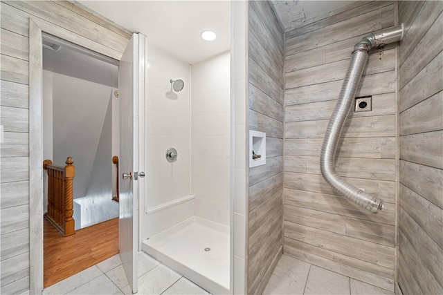 bathroom with wood-type flooring and tiled shower