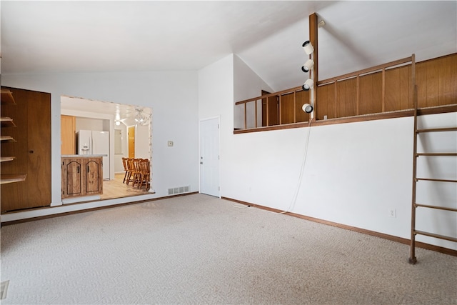 empty room with carpet floors and vaulted ceiling