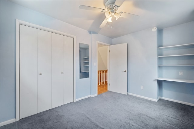 unfurnished bedroom with ceiling fan, a closet, and dark colored carpet