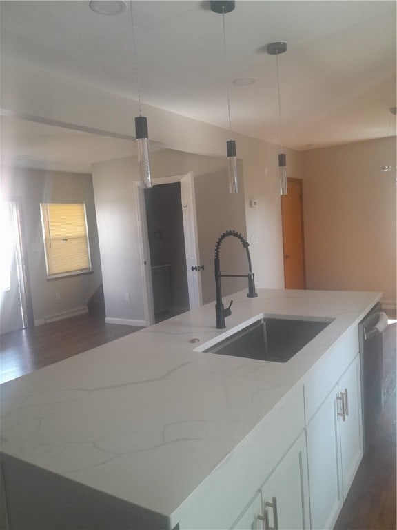 kitchen featuring sink, a center island with sink, dishwasher, white cabinets, and hanging light fixtures