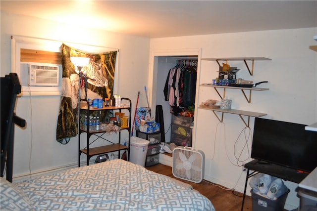 bedroom with a wall mounted AC, a closet, and dark hardwood / wood-style flooring