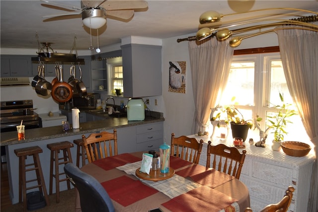 dining space with ceiling fan and sink