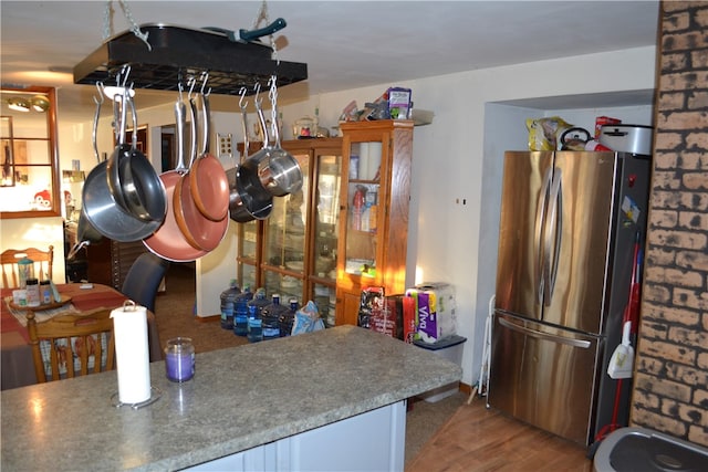 kitchen with stainless steel refrigerator and hardwood / wood-style floors