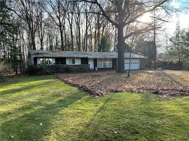 single story home featuring a garage and a front lawn