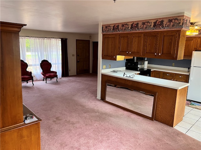 kitchen featuring white refrigerator, kitchen peninsula, light carpet, and black range with electric cooktop