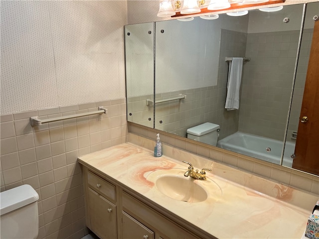 full bathroom with vanity, toilet, shower / washtub combination, and tile walls