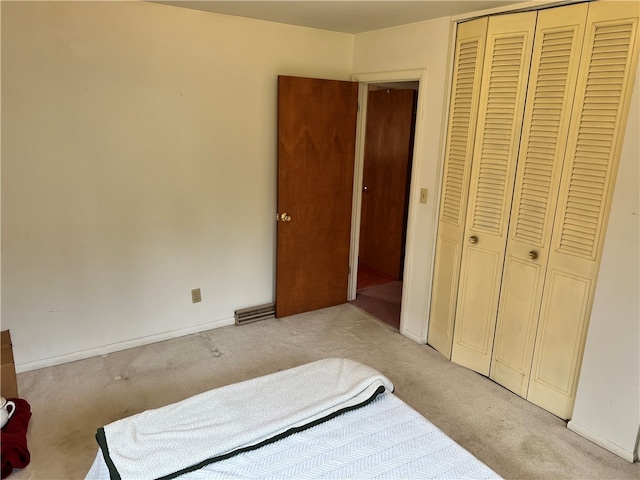 bedroom featuring light carpet and a closet