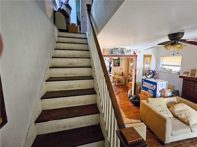 stairway featuring hardwood / wood-style flooring and ceiling fan