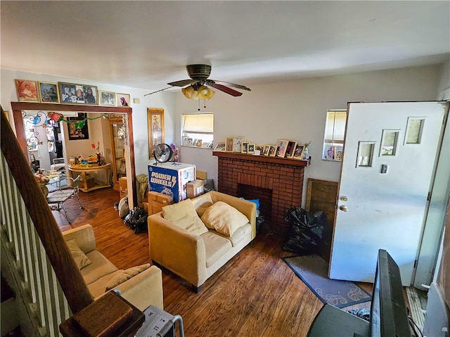 living room featuring ceiling fan, a fireplace, and dark hardwood / wood-style floors