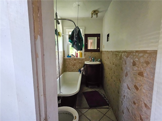 bathroom featuring toilet, tile patterned floors, and tile walls